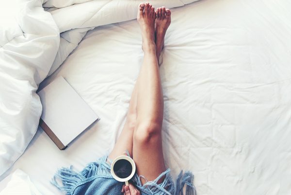 Woman lounging with coffee and a book