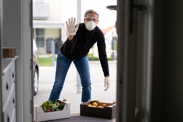 man delivering produce wearing gloves and face mask