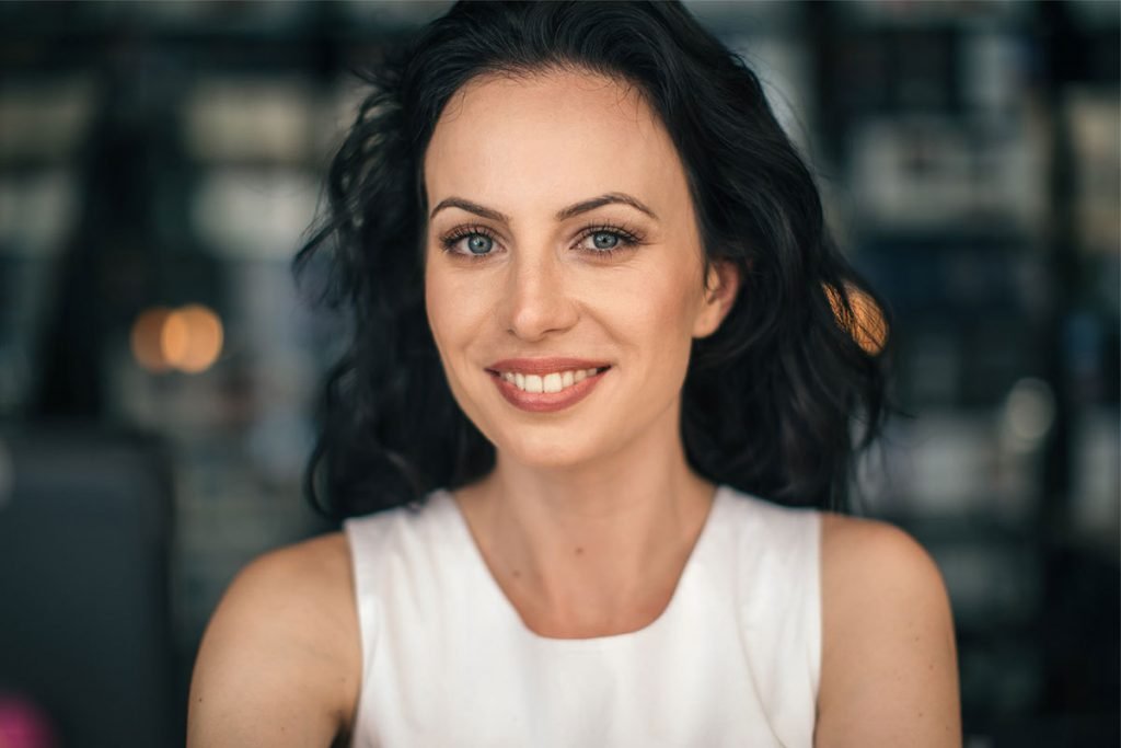 smiling brunette with rejuvenated eyebrows after botox